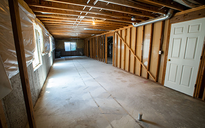 Unfinished basement with exposed framing and electrical wiring